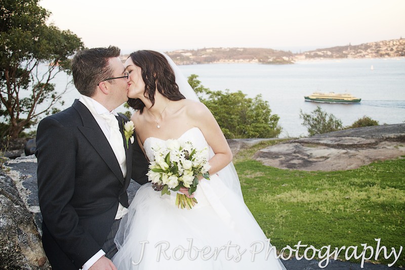 Couple kissing with sydney harbour behind - wedding photography sydney